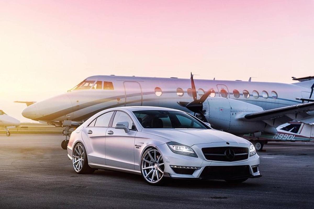 a white car parked in front of an airplane