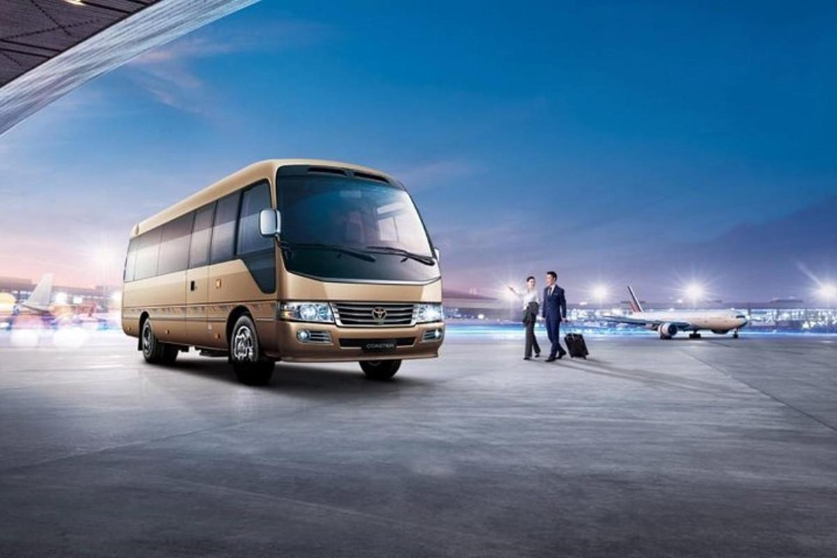 two men are standing next to a bus in an airport