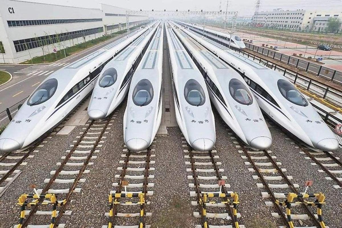 a row of white trains parked on train tracks