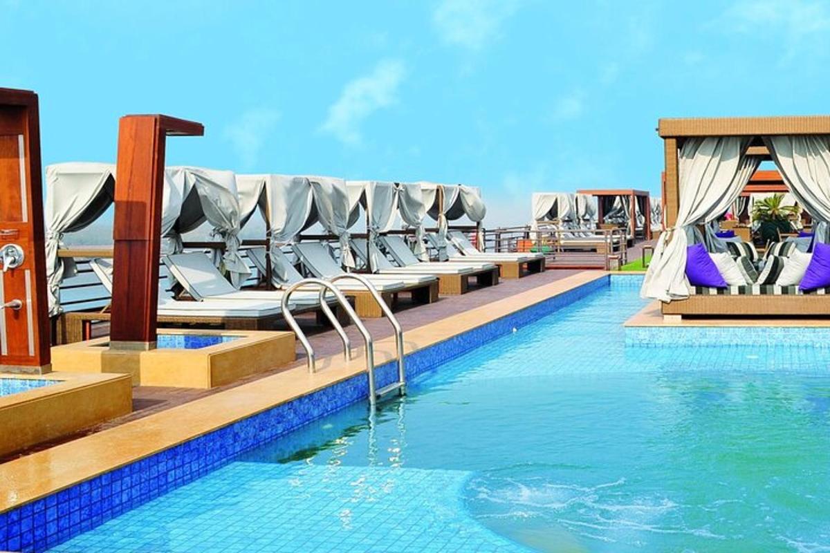 une piscine avec des chaises longues dans un complexe hôtelier