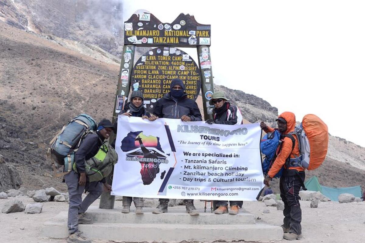un gruppo di persone che tengono un grande cartello su una montagna