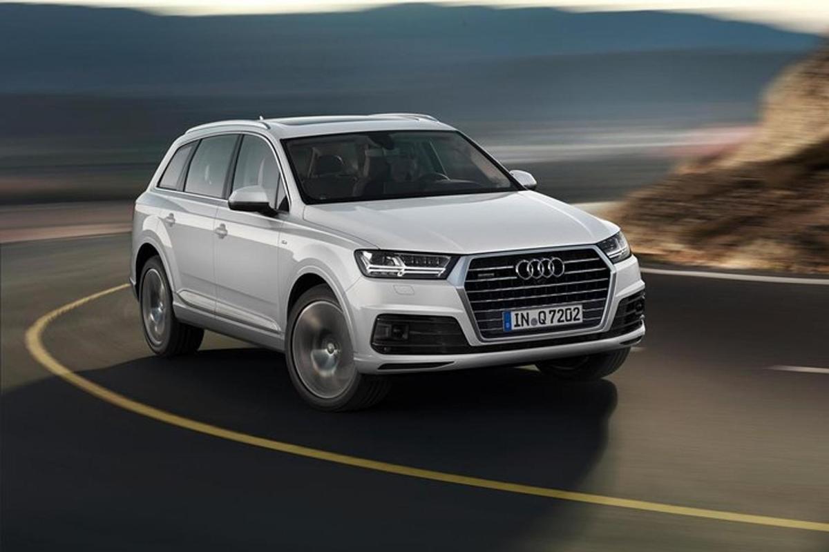 en hvit Audi SUV som kjører nedover en vei