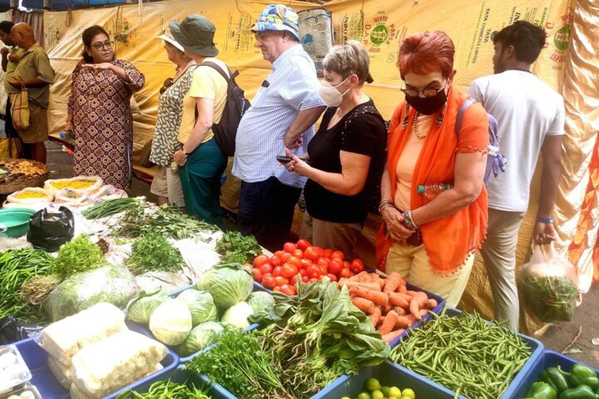 um grupo de pessoas em pé ao redor de uma mesa de vegetais