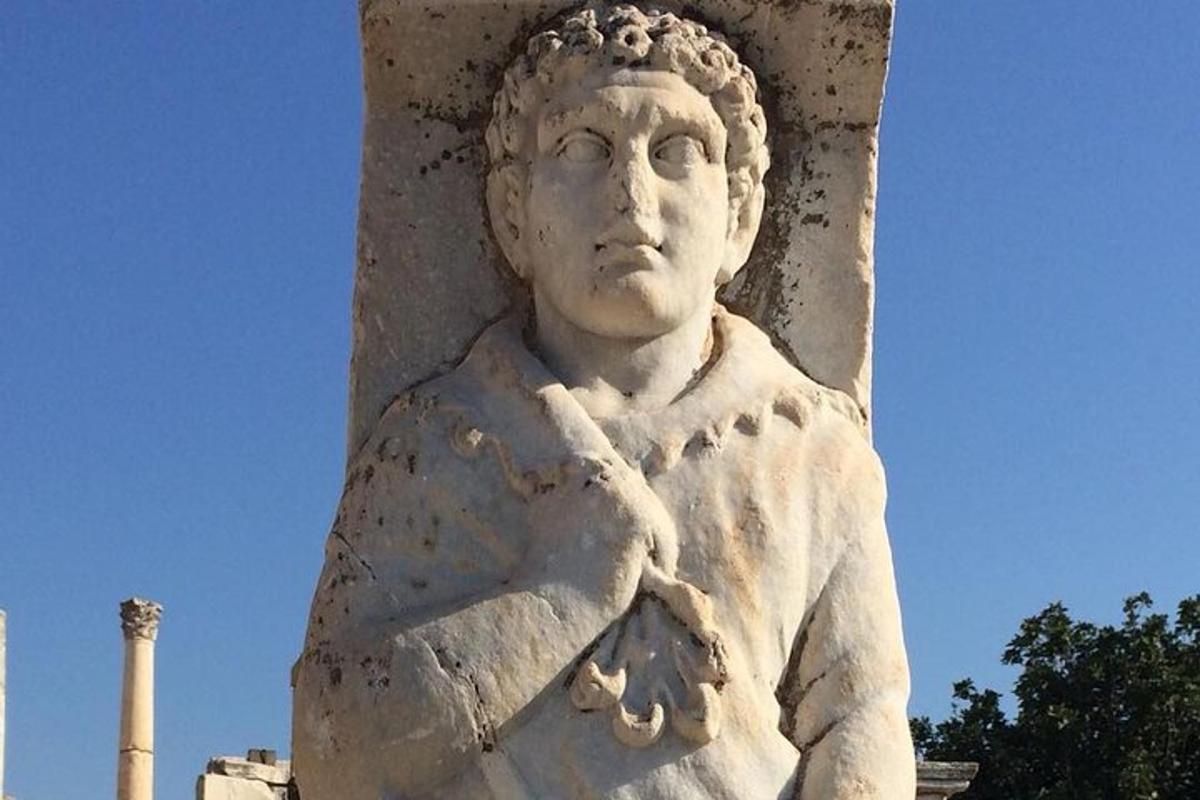 ένα άγαλμα μιας γυναίκας που στέκεται δίπλα σε έναν στύλο