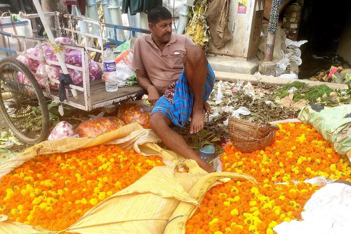 a man sitting on a pile of oranges in a market