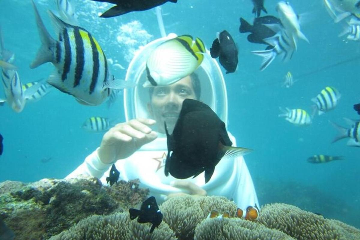 一名男子在水族馆里，手里拿着一条鱼
