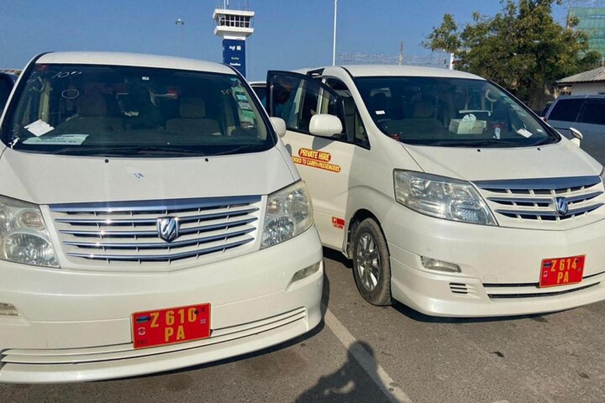 duas vans brancas estacionadas uma ao lado da outra