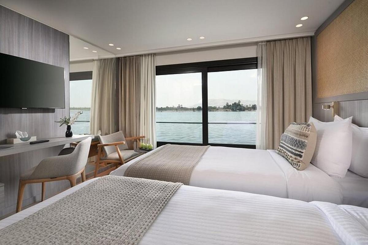 una habitació d'hotel amb dos llits i una finestra gran