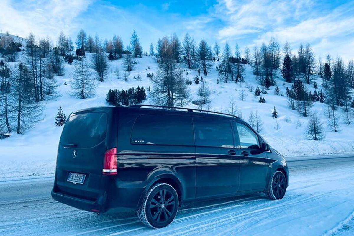 ein blauer SUV fährt eine schneebedeckte Straße entlang