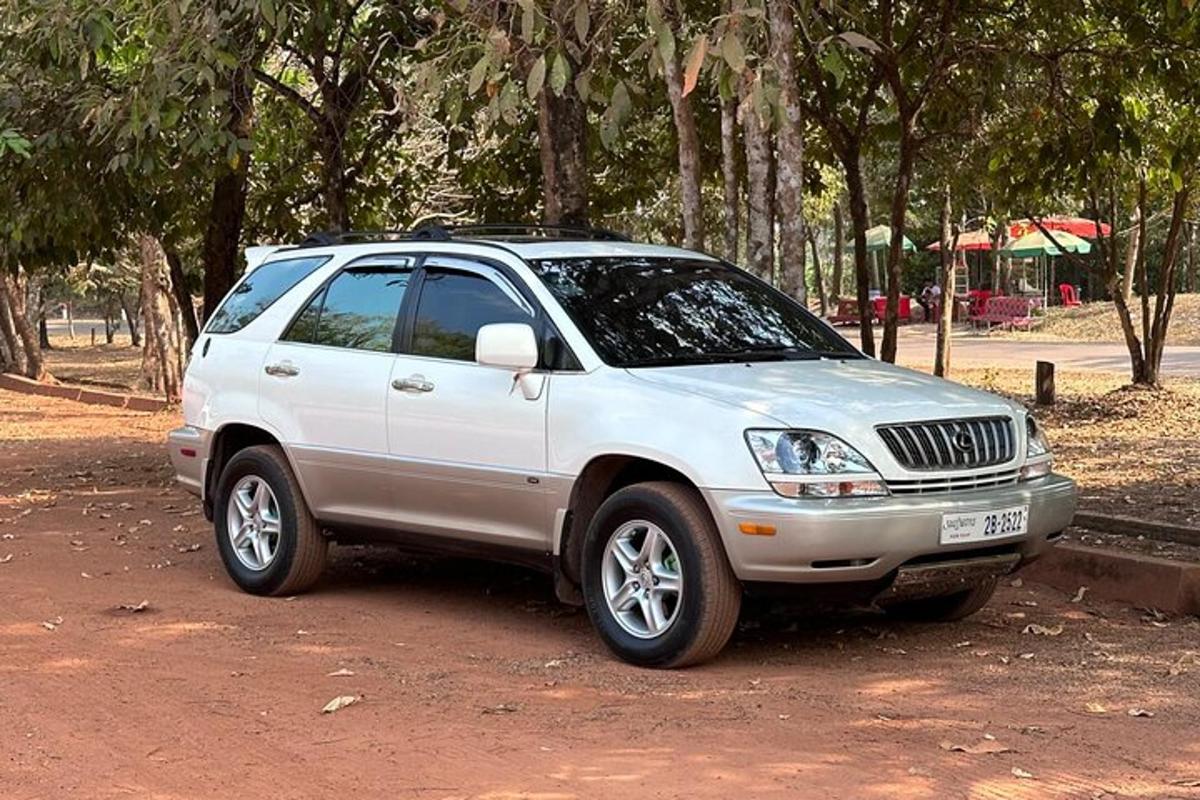 en hvit SUV parkert på en grusvei