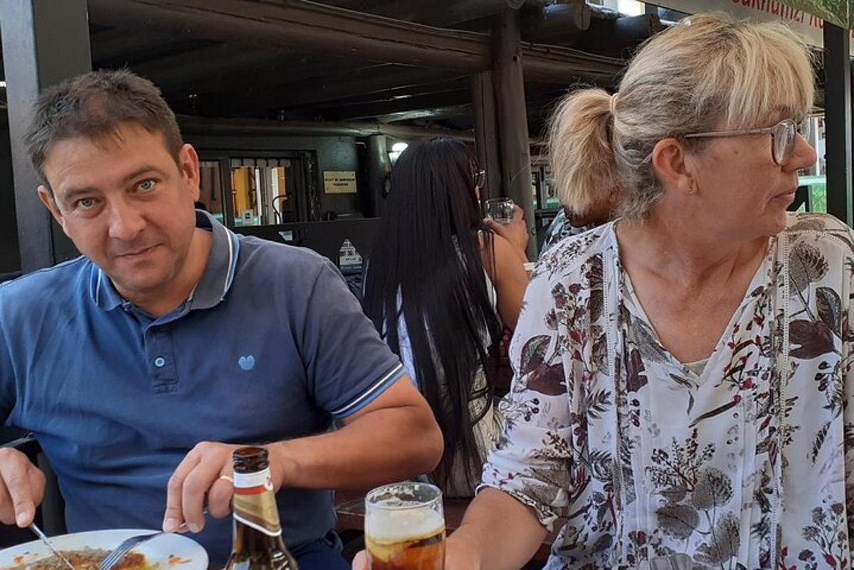 moški in ženska sedita za mizo s krožnikom hrane