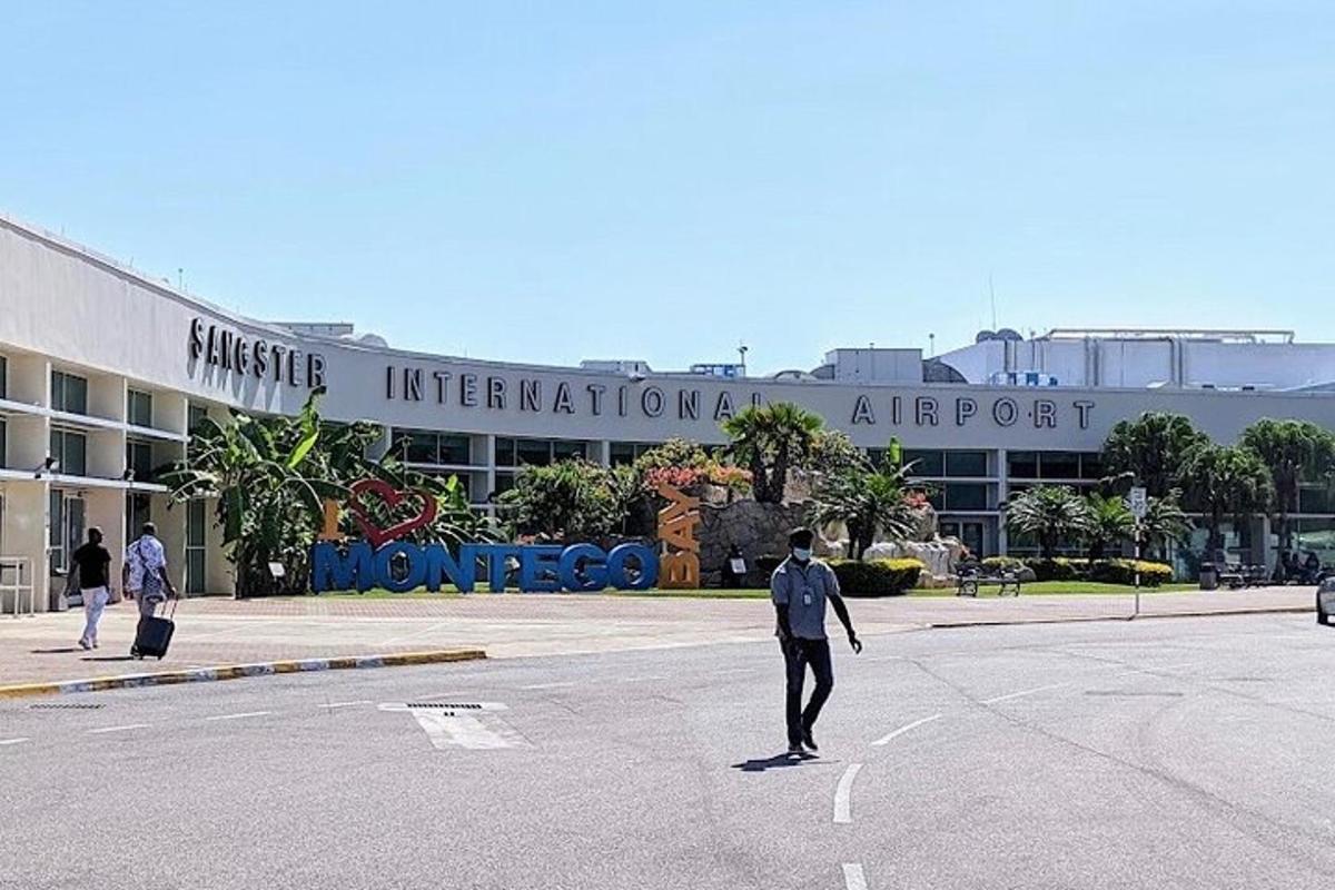 un home creuant un carrer davant d'un aeroport
