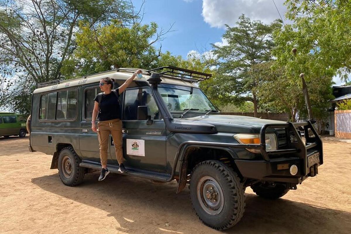 un home dret a la part posterior d'un jeep verd
