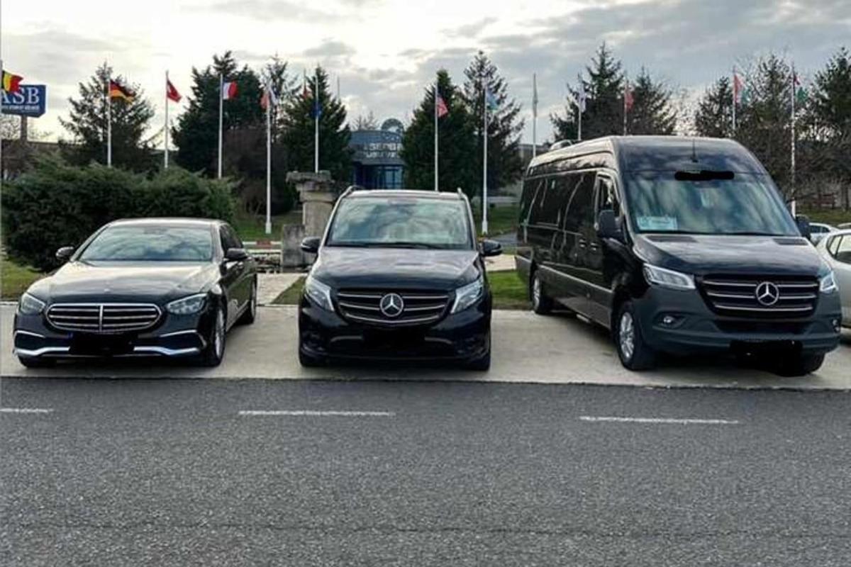 dois carros e uma van estacionados em um estacionamento