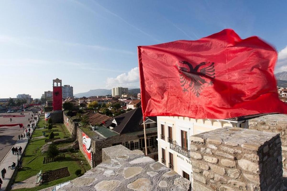 una bandera en lo alto de un edificio con una ciudad