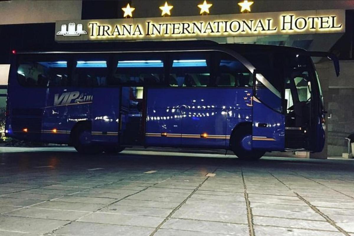 Un autobús azul estacionado frente a un hotel.
