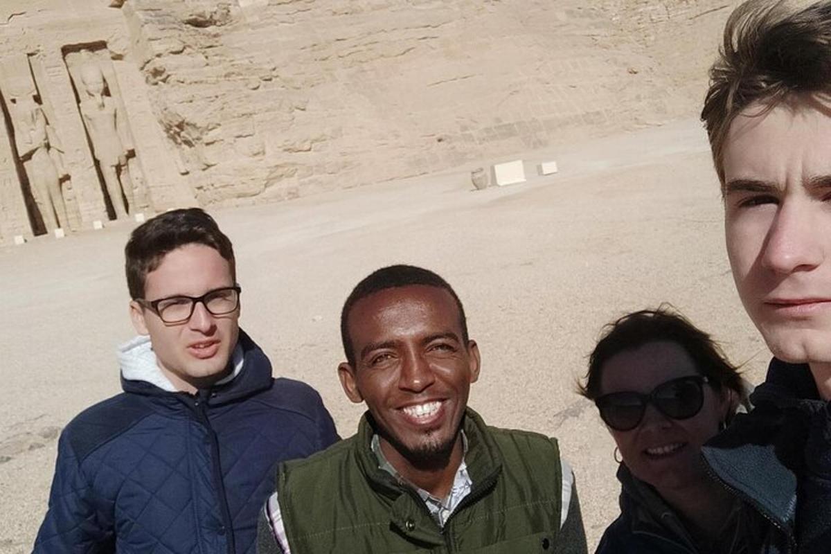 um grupo de homens em pé em frente a uma pirâmide