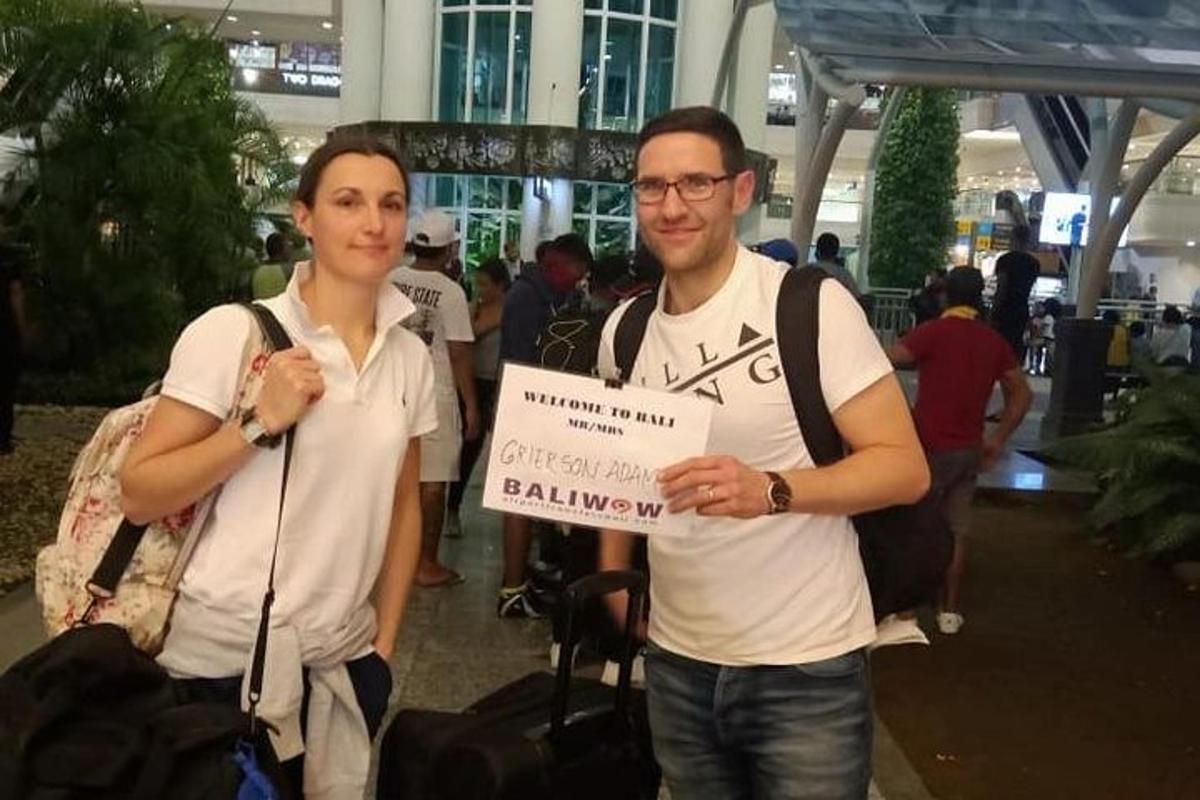 two men are holding a sign at an airport