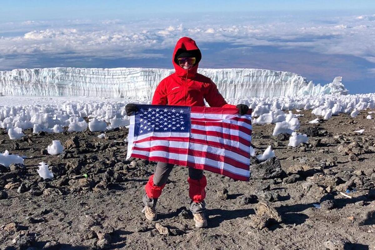 seseorang yang memegang bendera amerika di atas glasier