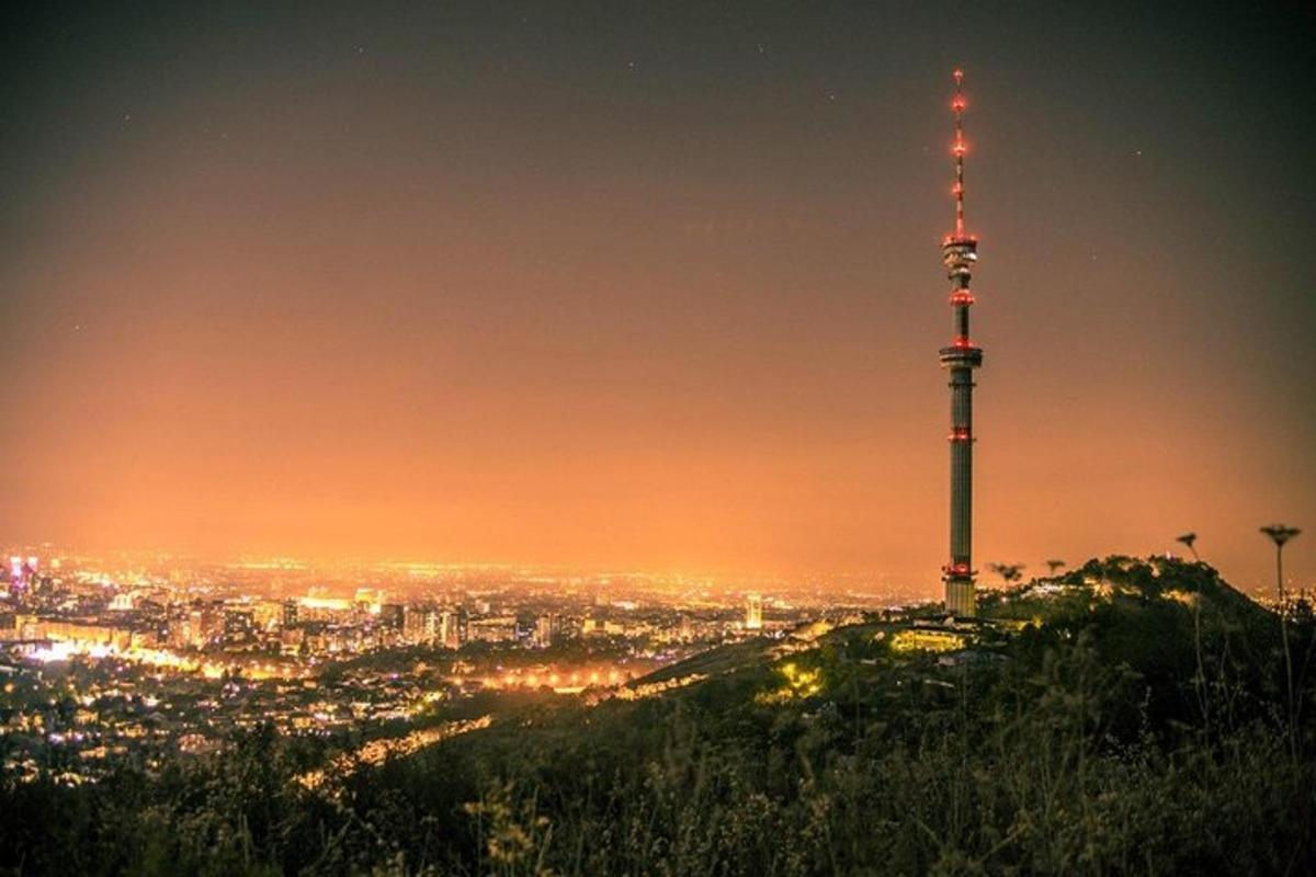una torre televisiva in cima a una collina di notte