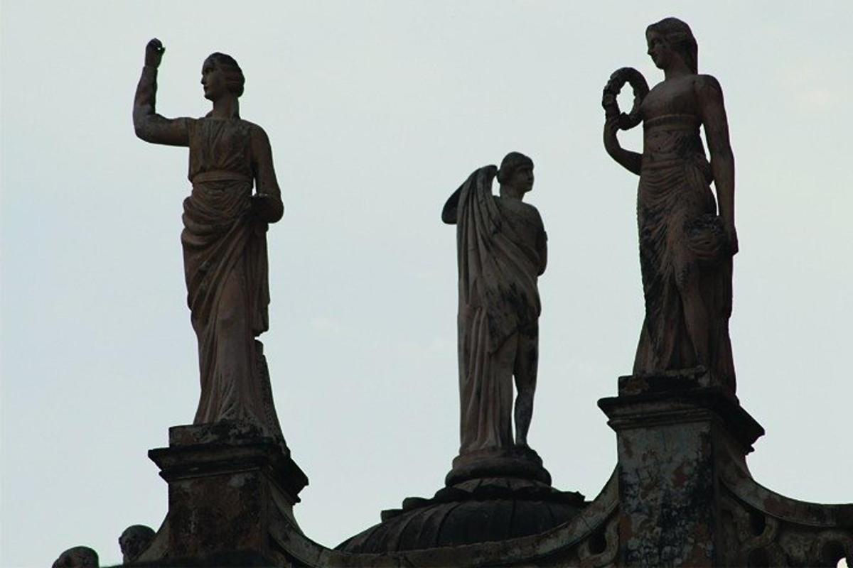 tři sochy lidí na střeše budovy