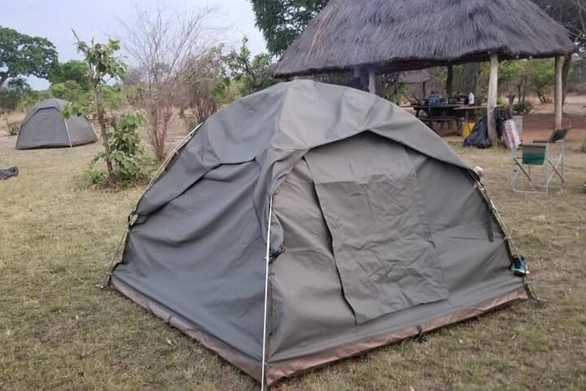 a tent sitting in the grass in a field