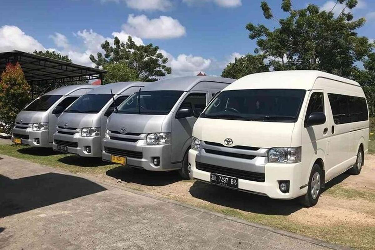 quatro vans estacionadas em fila em um estacionamento