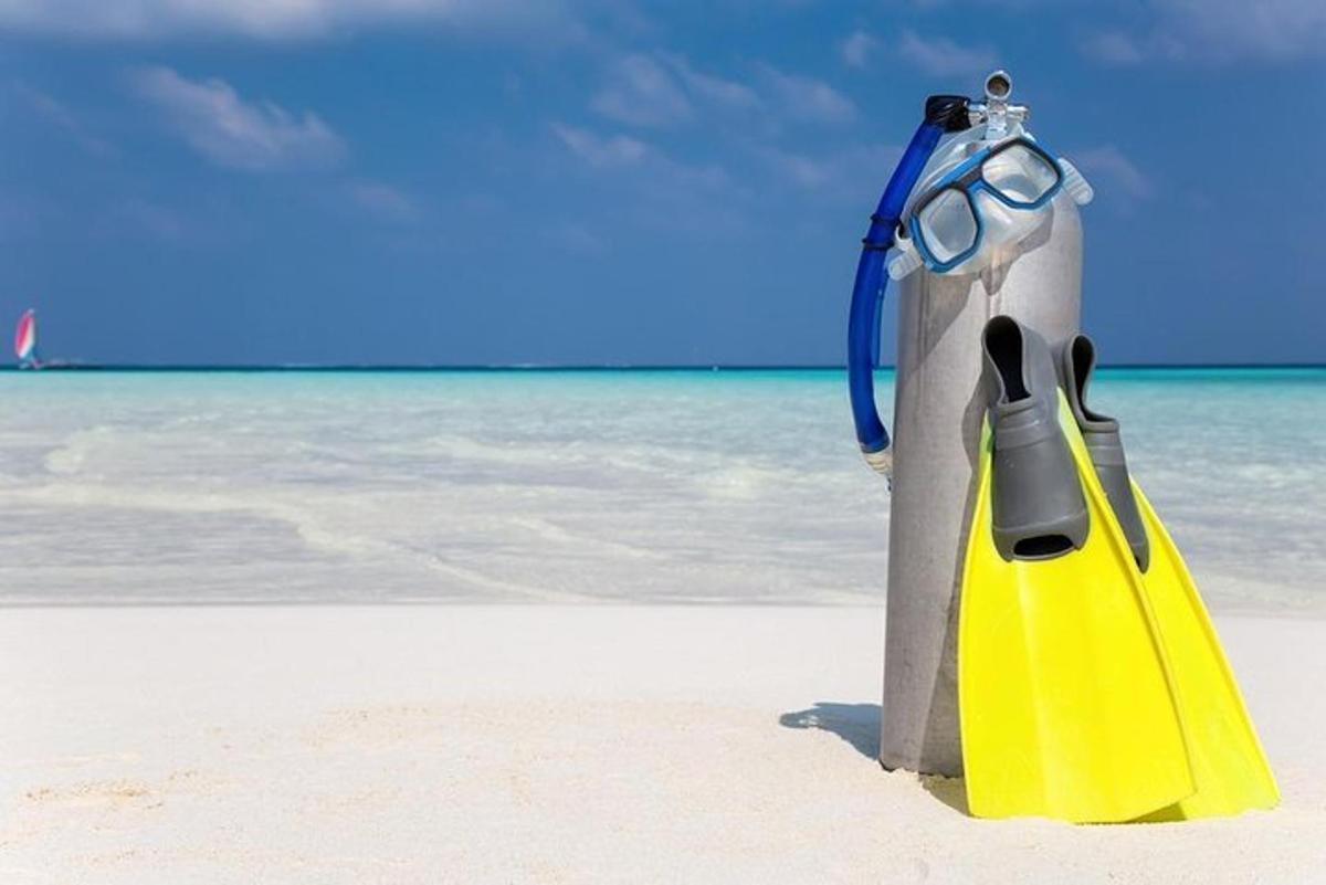 Un par de gafas encima de una botella en la playa.