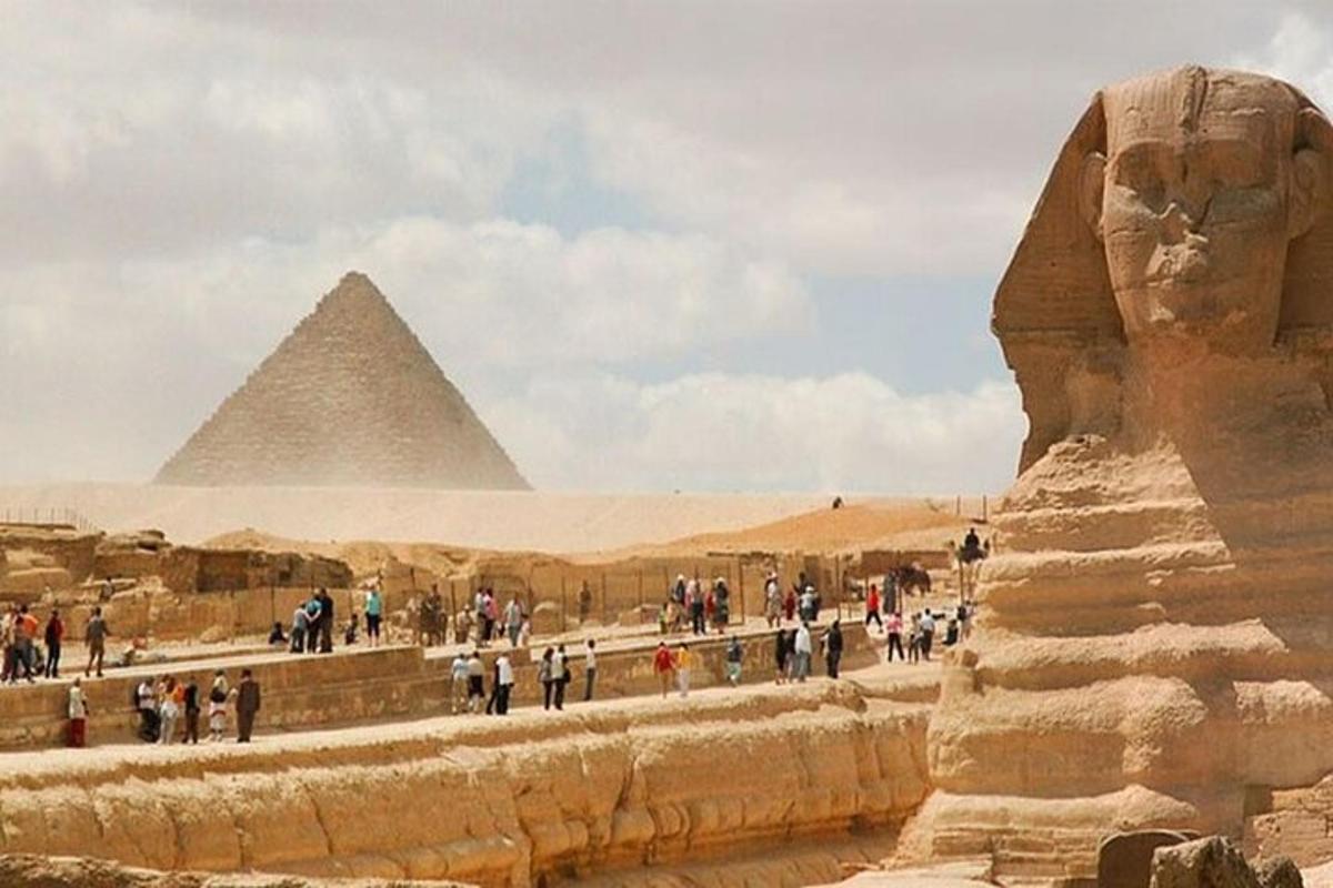 skupina ľudí prechádzajúcich sa okolo pyramíd