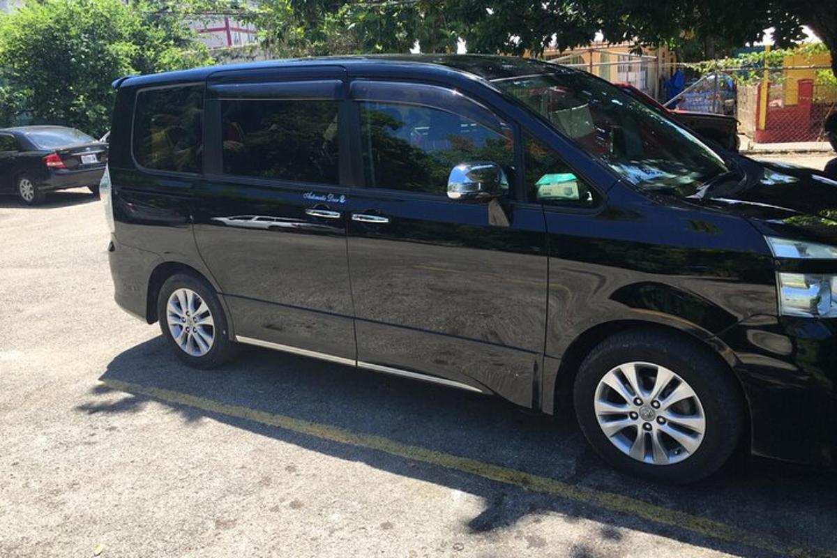 uma pequena van preta estacionada em um estacionamento