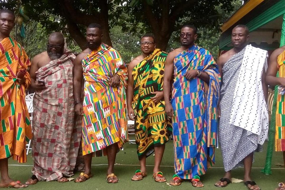 Un grupo de hombres con vestidos coloridos posando para una fotografía.