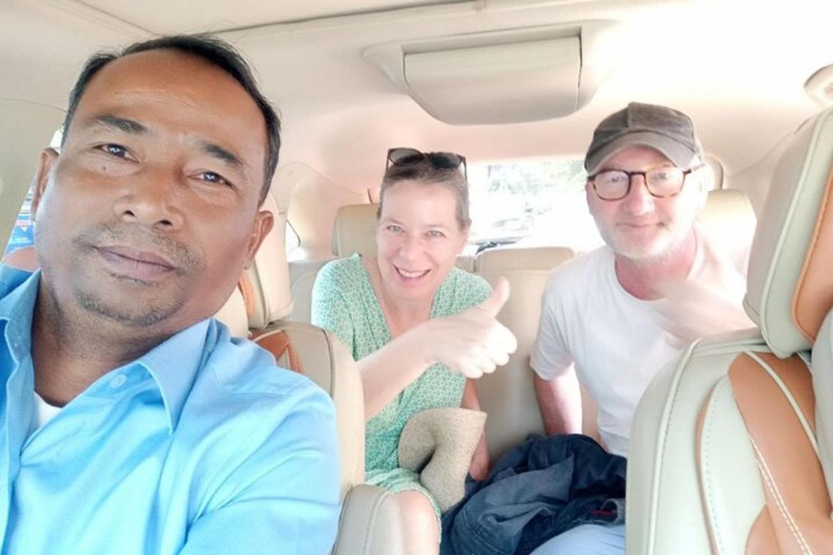 three people sitting in the back of a car
