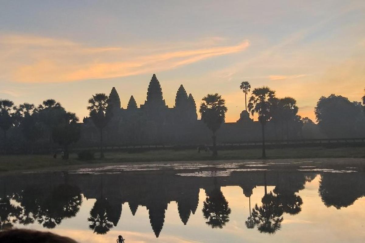 a silhouette of a temple with a reflection in a body of water