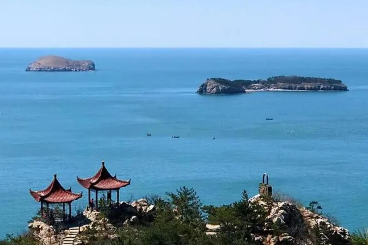 an island in the ocean with two pagodas on a hill