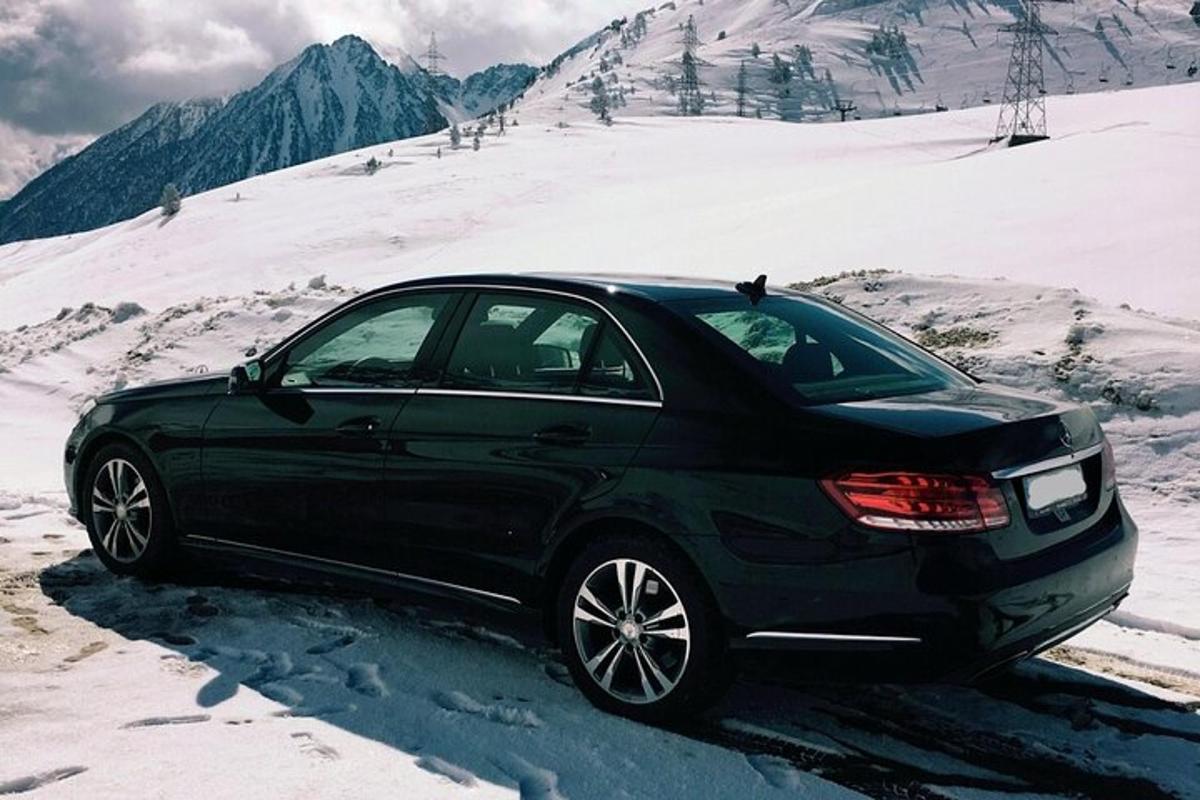 černé auto zaparkované na zasněžené hoře