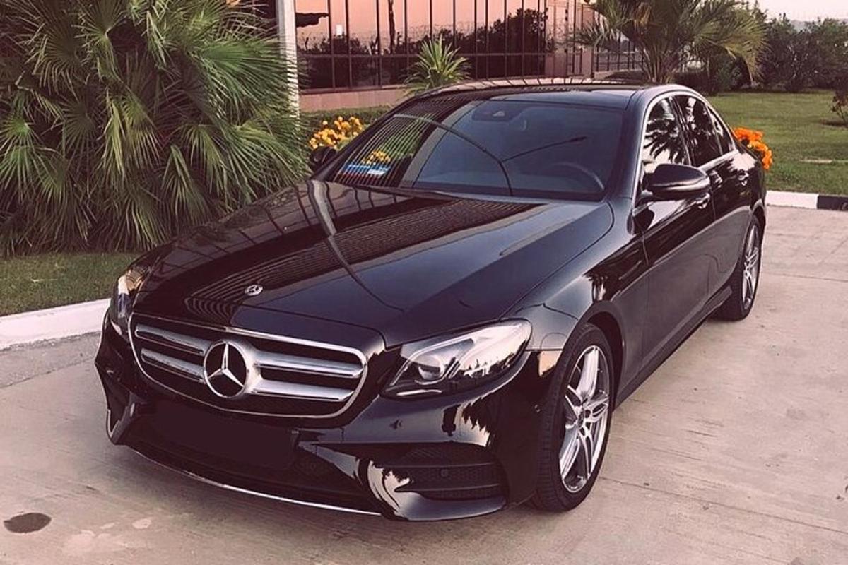 a black mercedes benz car parked in a driveway