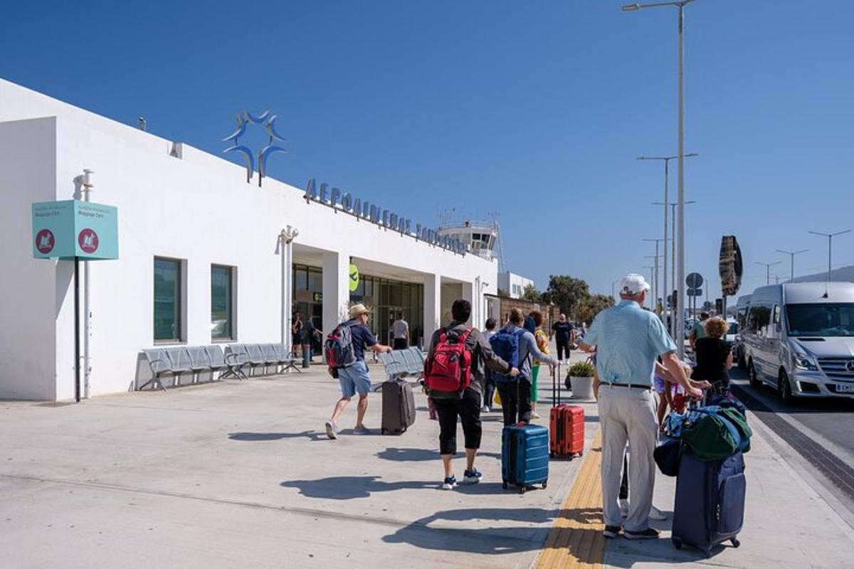 a group of people walking down a sidewalk with luggage