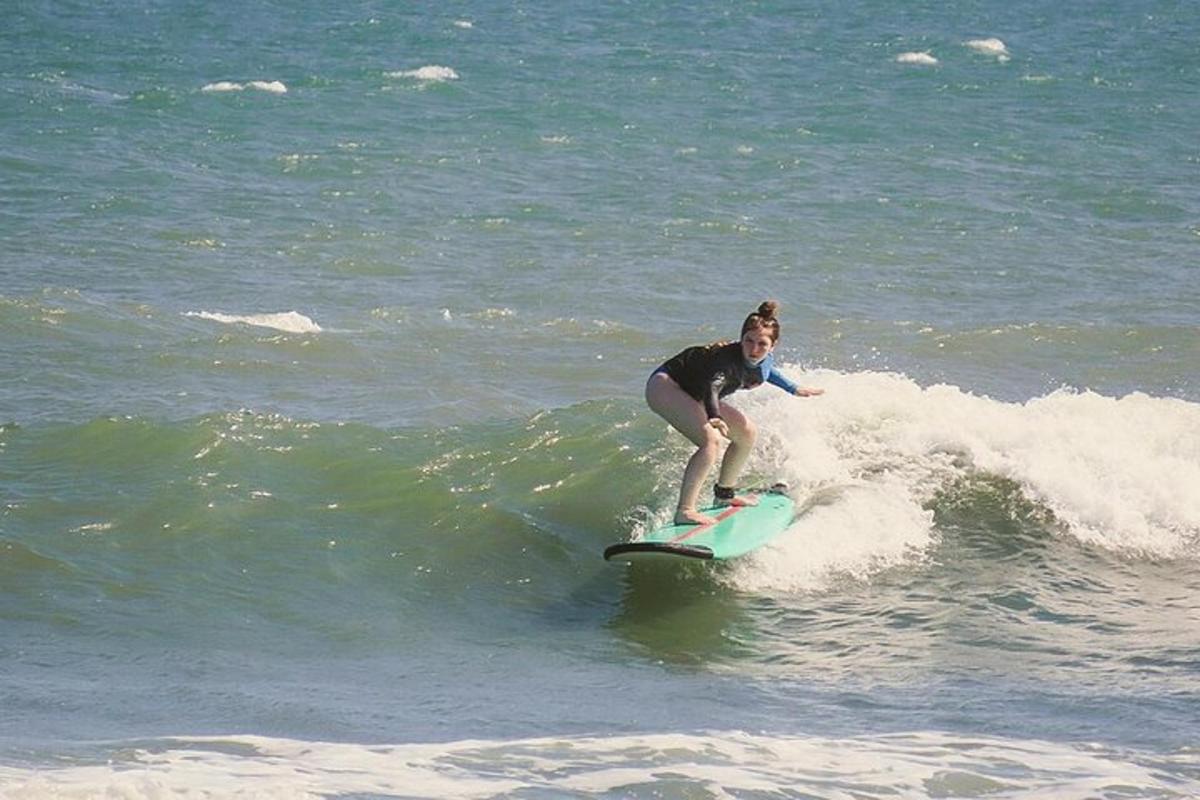 en kvinne som rir på en bølge på et surfebrett i havet
