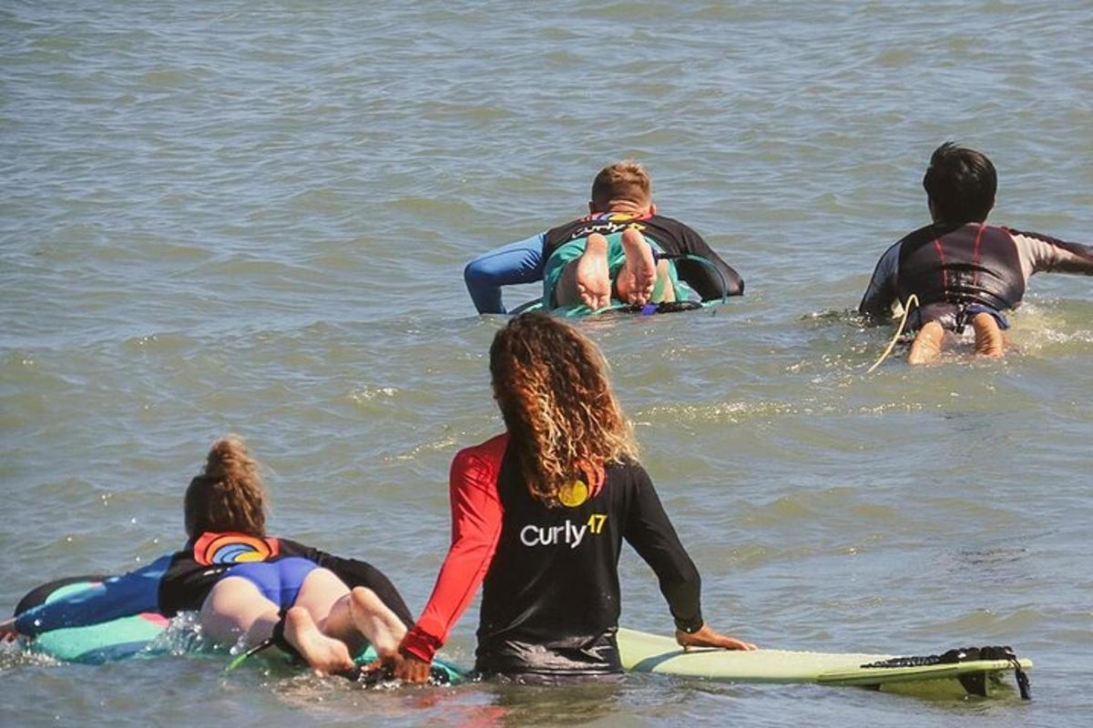 en gruppe mennesker som sitter på surfebrett i vannet