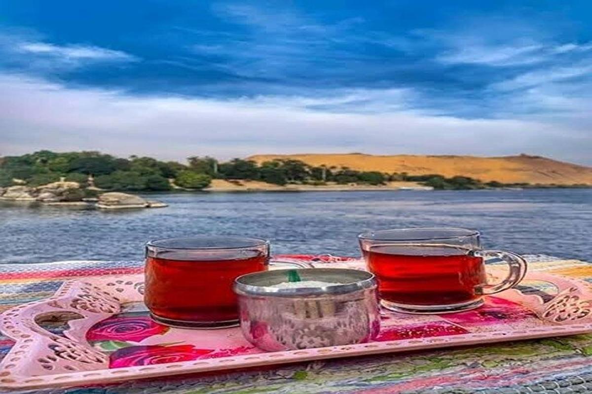 una safata amb dues tasses de te sobre una taula vora l'aigua