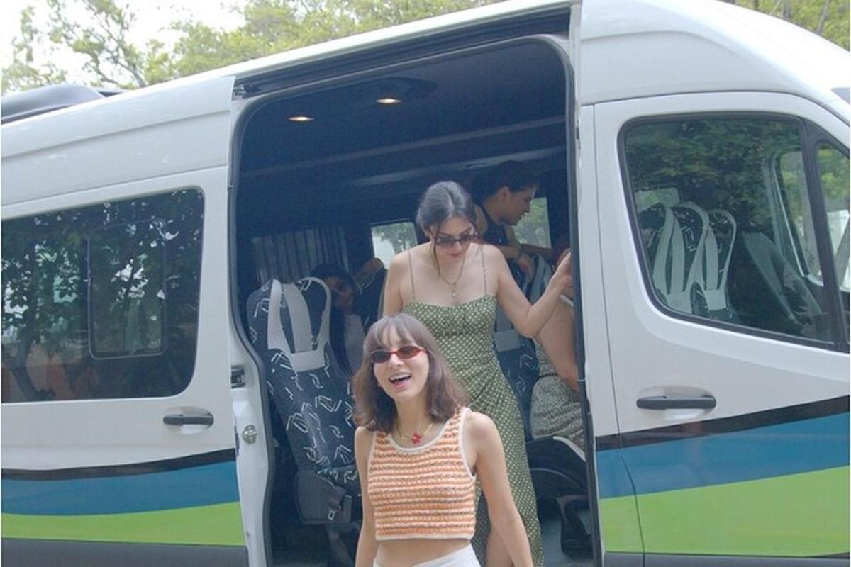 dalawang babaeng bumaba sa isang puti at berdeng bus