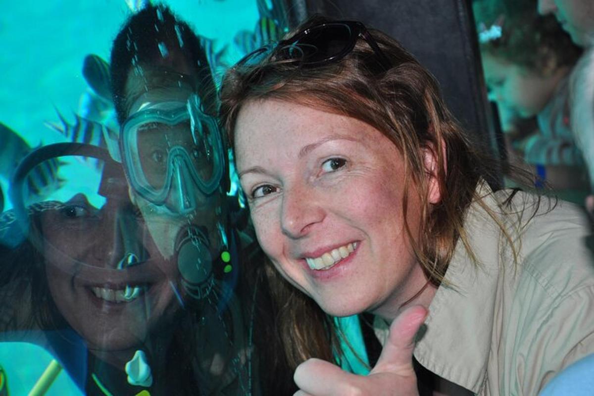 eine Frau, die vor einem Glasfenster einen Daumen hoch gibt