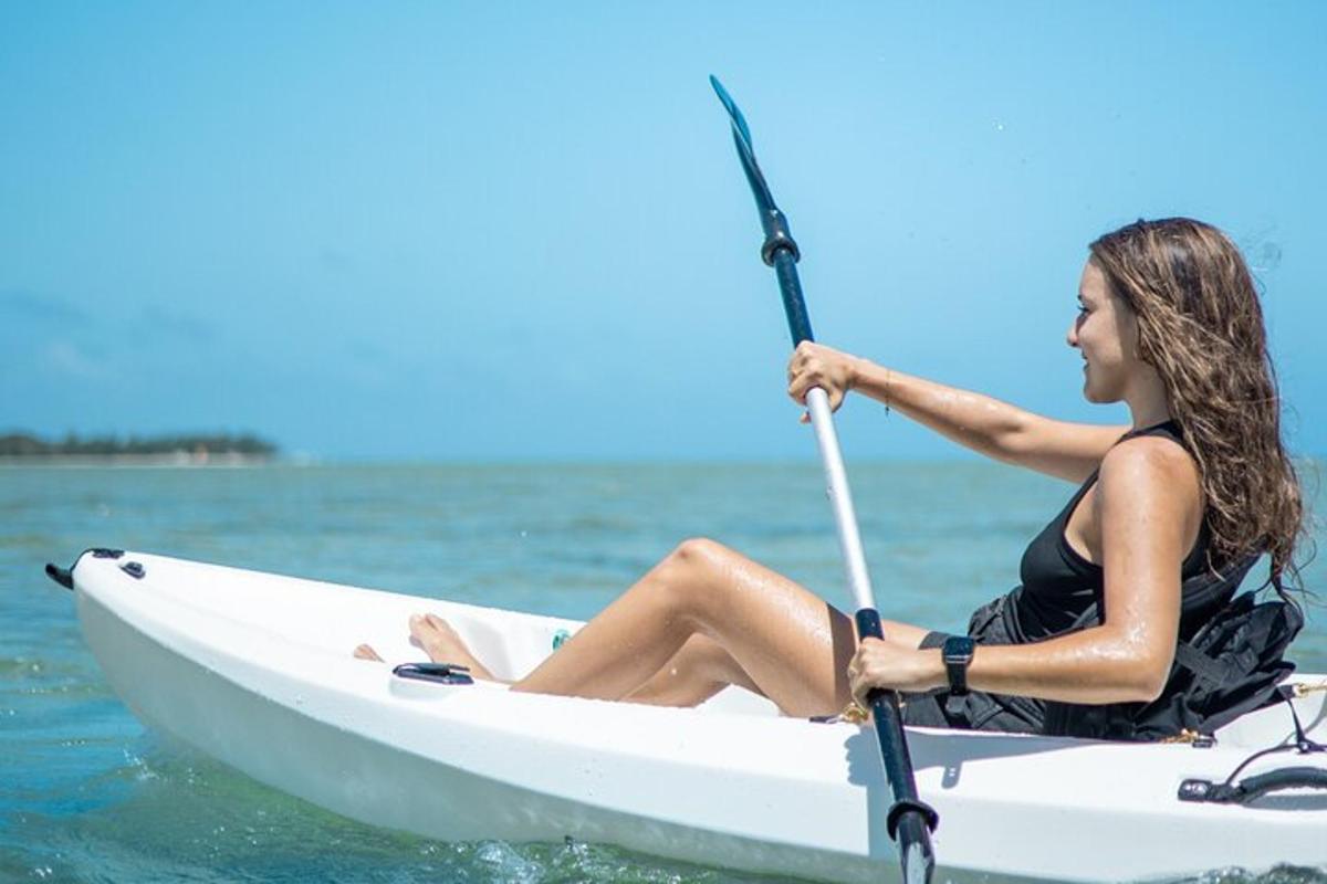 eine Frau, die auf einem Kajak im Wasser sitzt