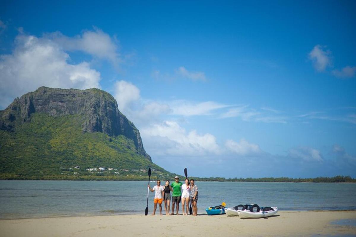 eine Gruppe von Menschen steht an einem Strand neben einem Boot