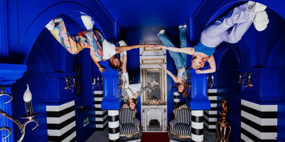 skupina lidí předvádí triky v modré místnosti