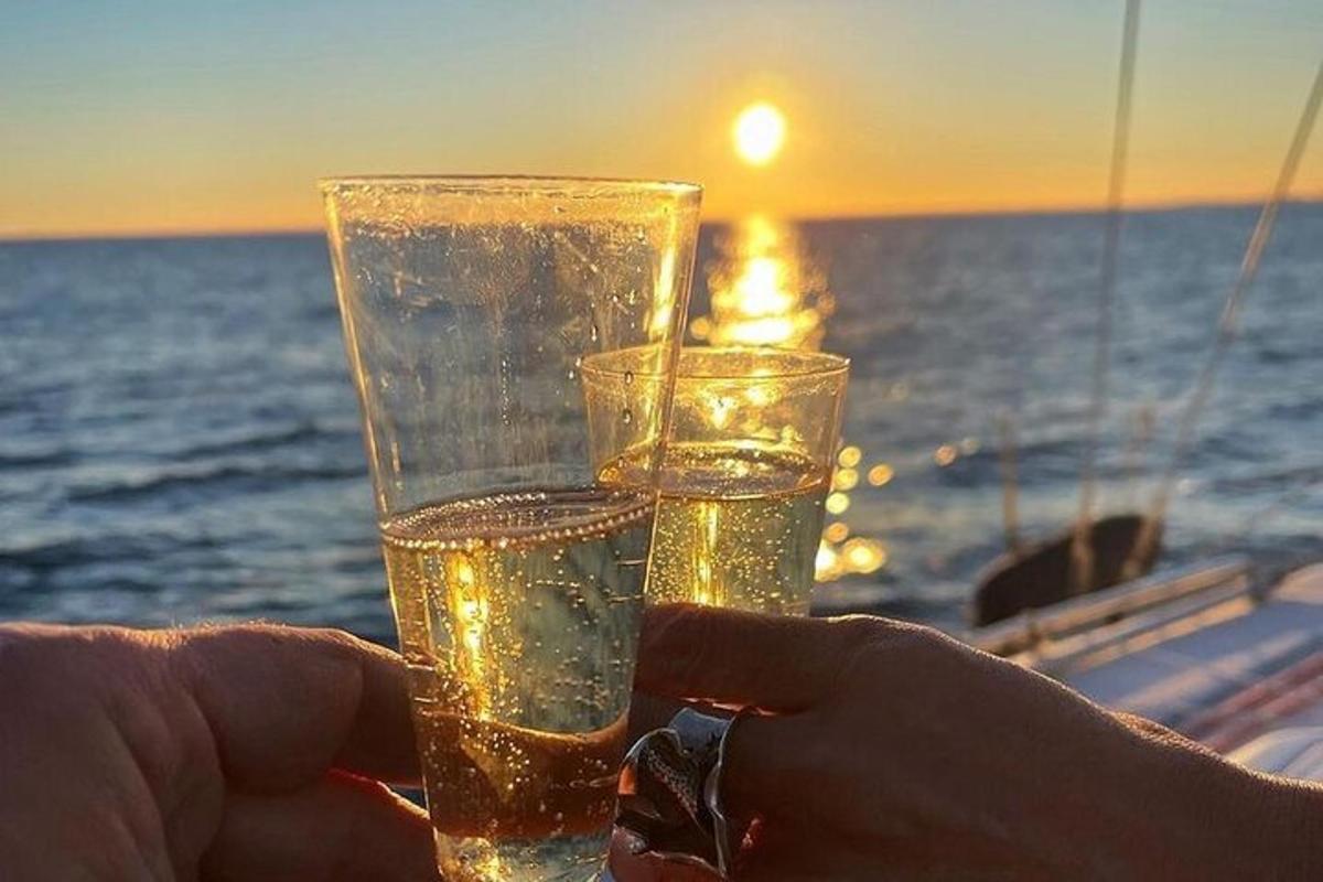 osoba držící sklenici vody před oceánem