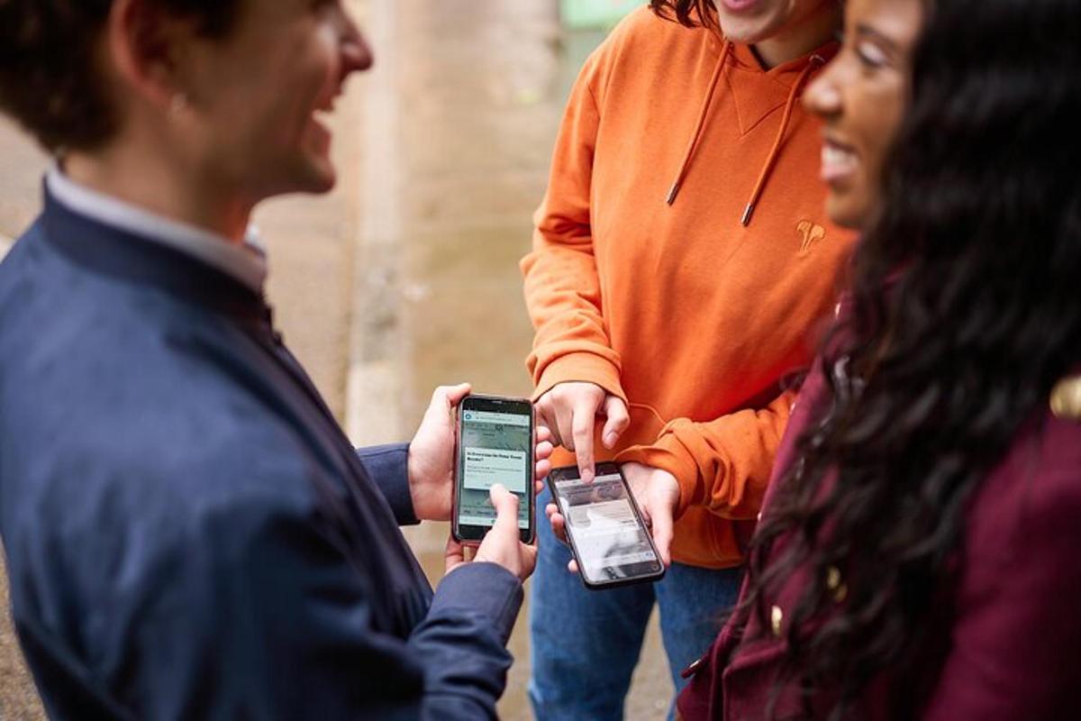 egy csoport ember tartja a magasba a mobiltelefonját