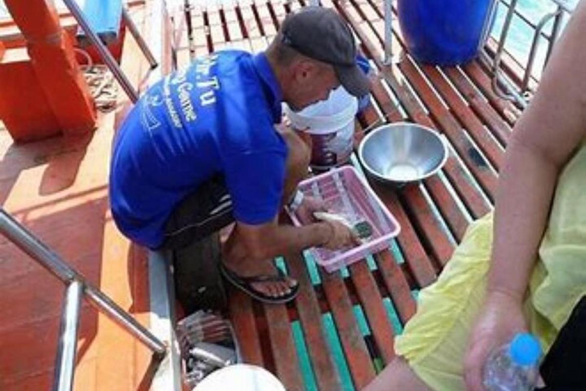 a man in blue shirt looking at a container
