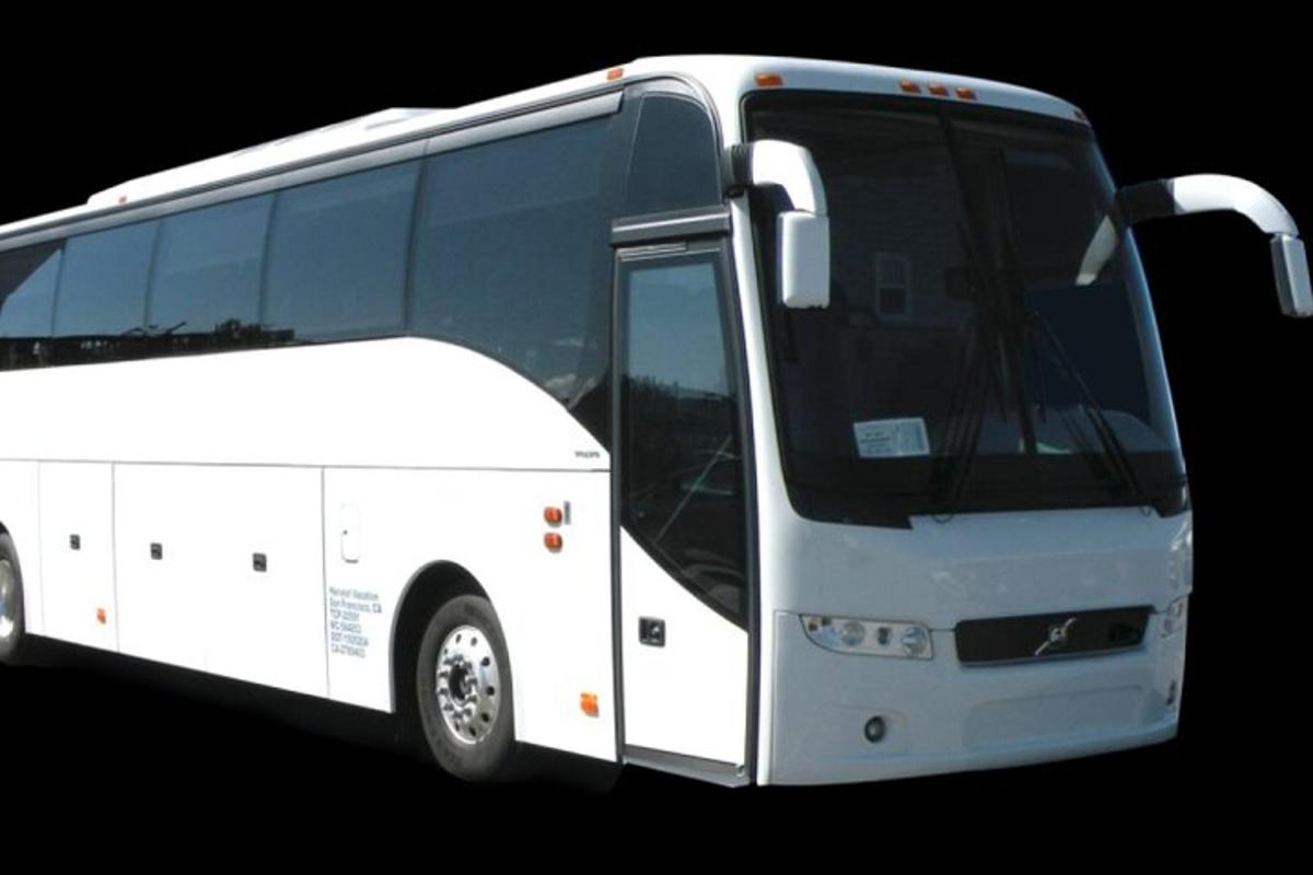 a white bus is parked with its door open