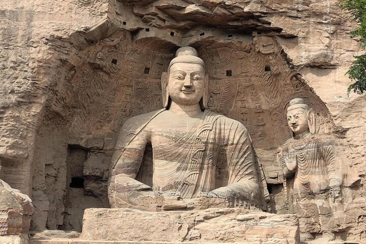 una statua di un uomo seduto davanti a un muro